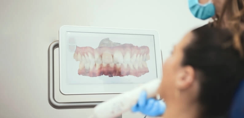 Dentiste analysant un rendu 3D d'une radiographie de la bouche d'un patient sur une tablette tactile