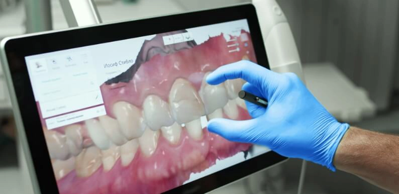 Dentiste analysant un rendu 3D d'une radiographie de la bouche d'un patient sur une tablette tactile